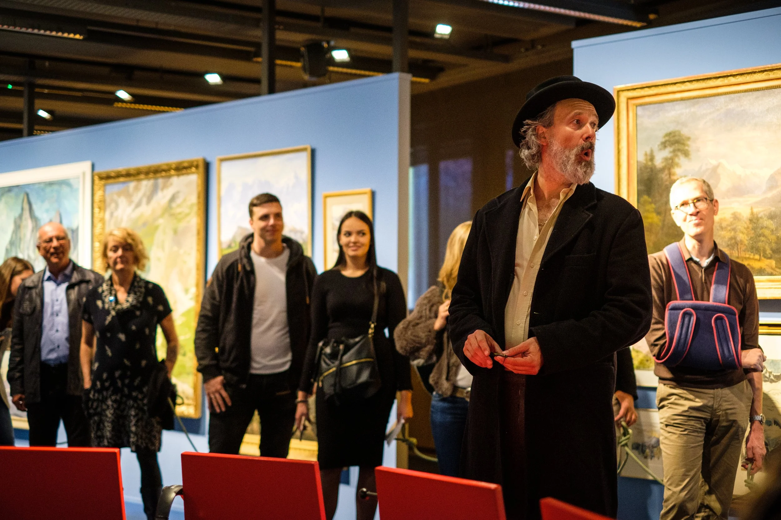 Menschen beim Kunstbesuch betrachten Gemälde in einer Galerie.