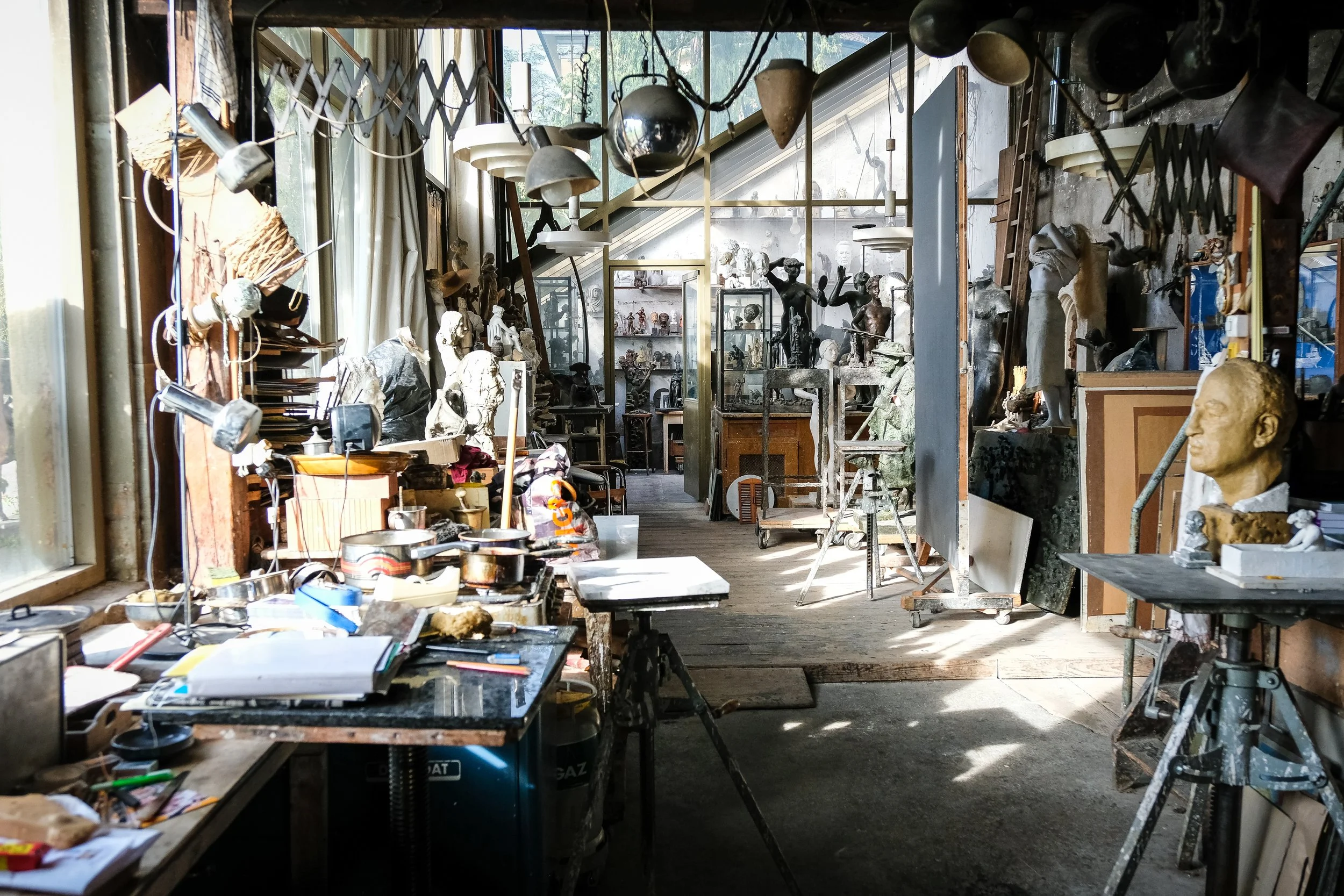 Kunststudio voller Skulpturen, Kunstwerke und Werkzeuge, mit viel natürlichem Licht durch Fenster