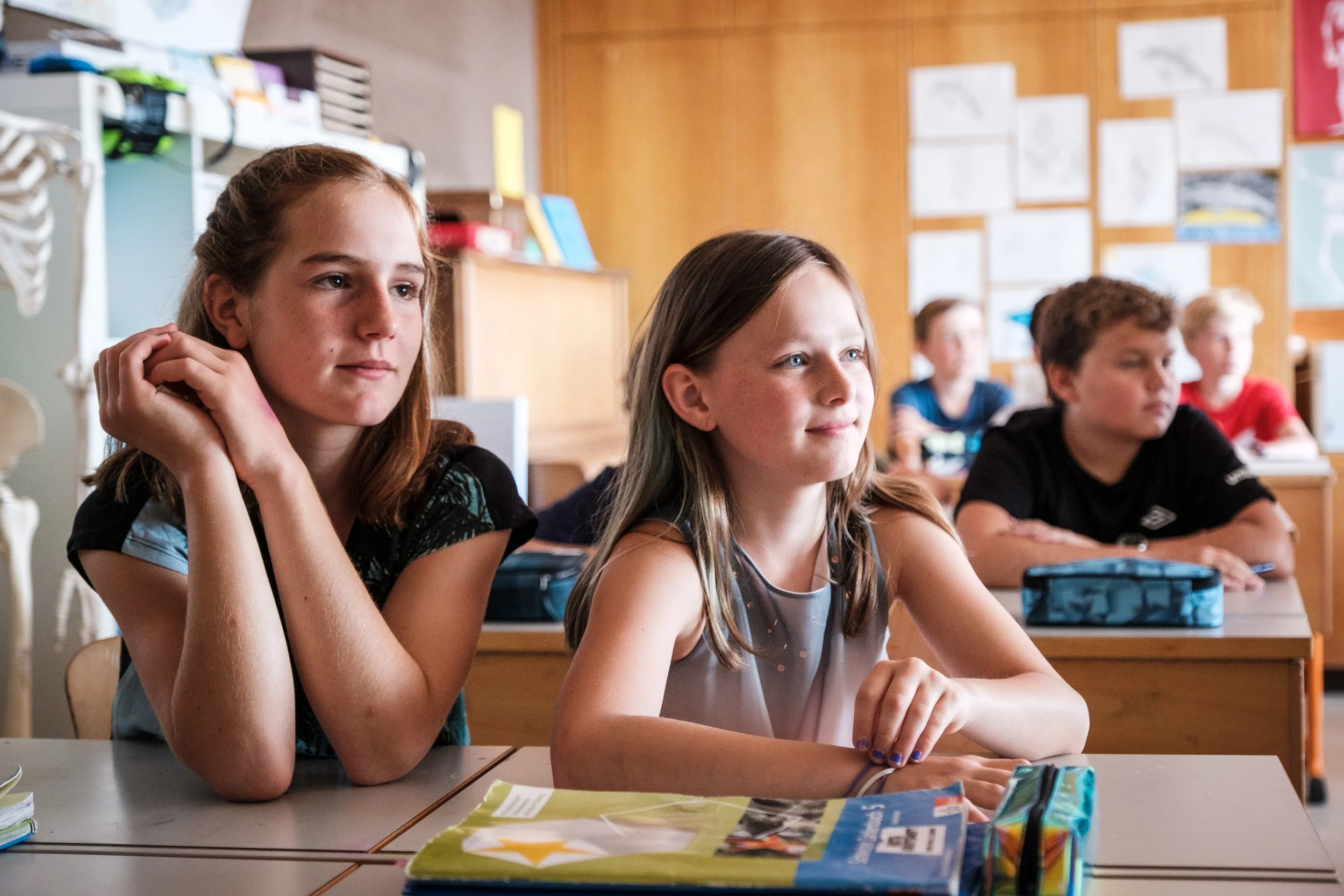 Schülerinnen sitzen im Klassenzimmer und hören aufmerksam zu
