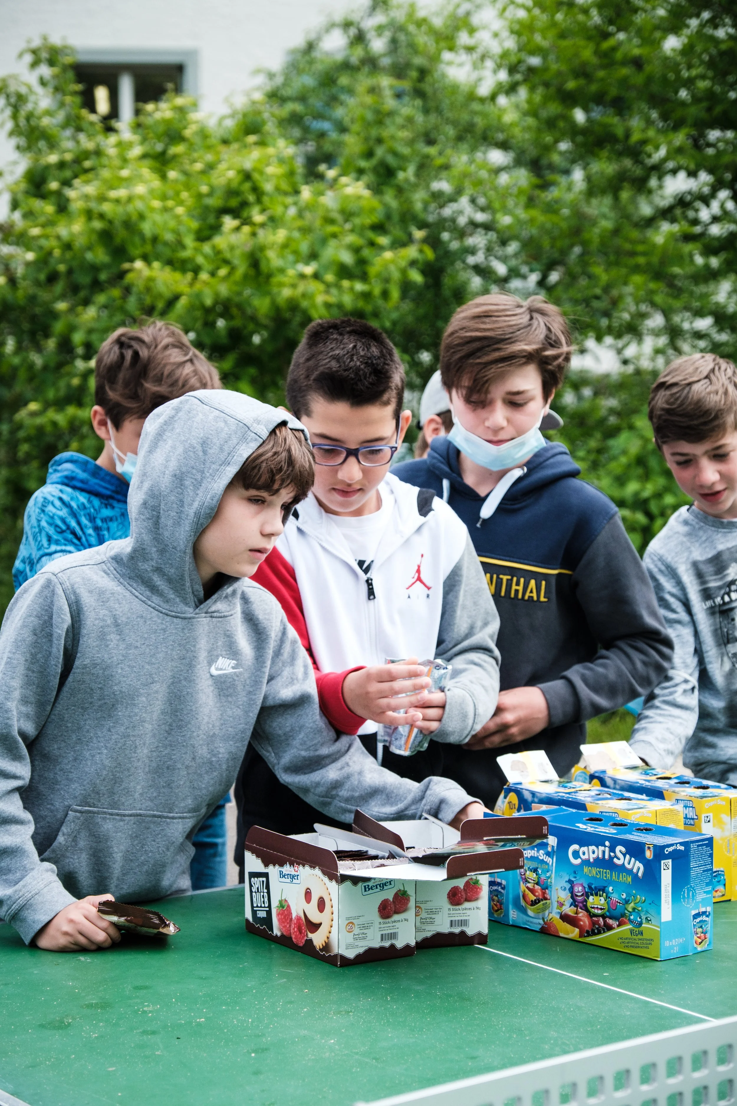 Junge Kinder beim Verteilen von Süßigkeiten im Freien.